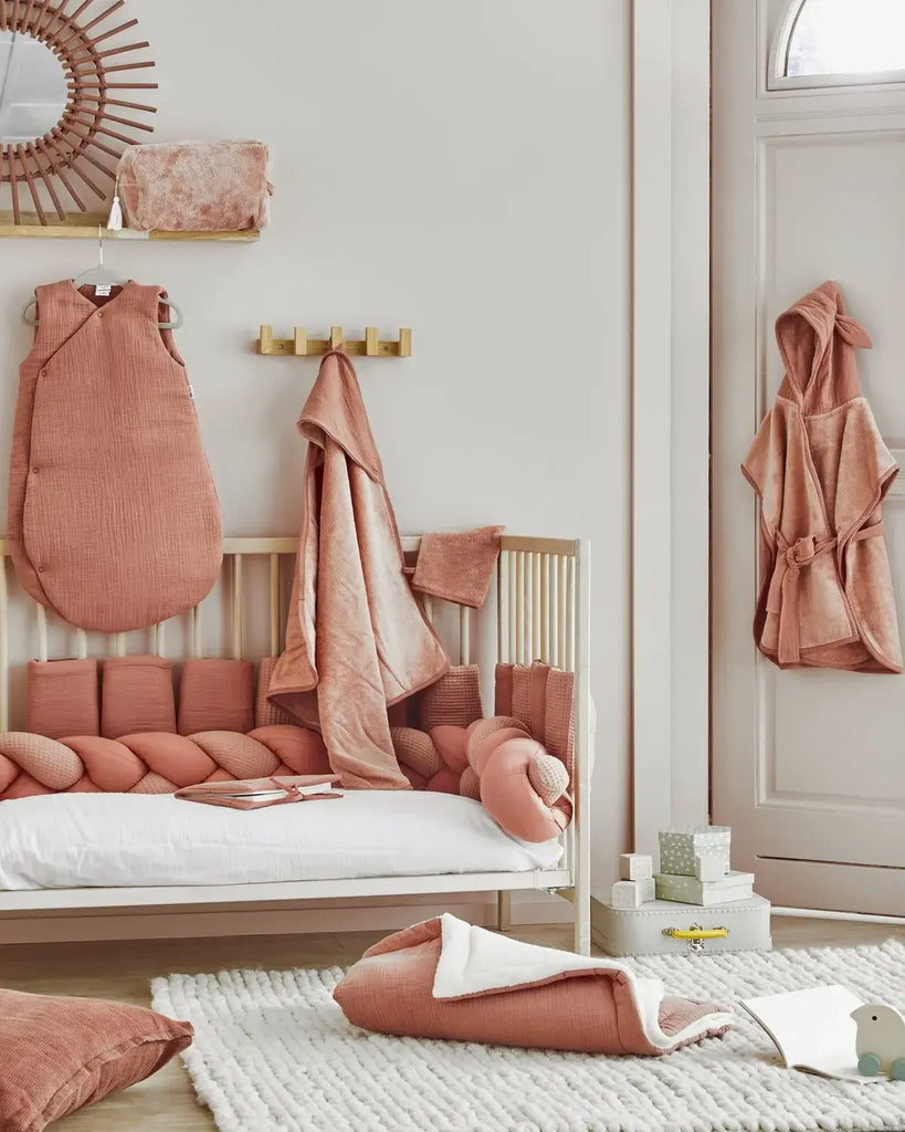 Photo d'une chambre avec différents vêtements de bain pour bébé de couleur marsala