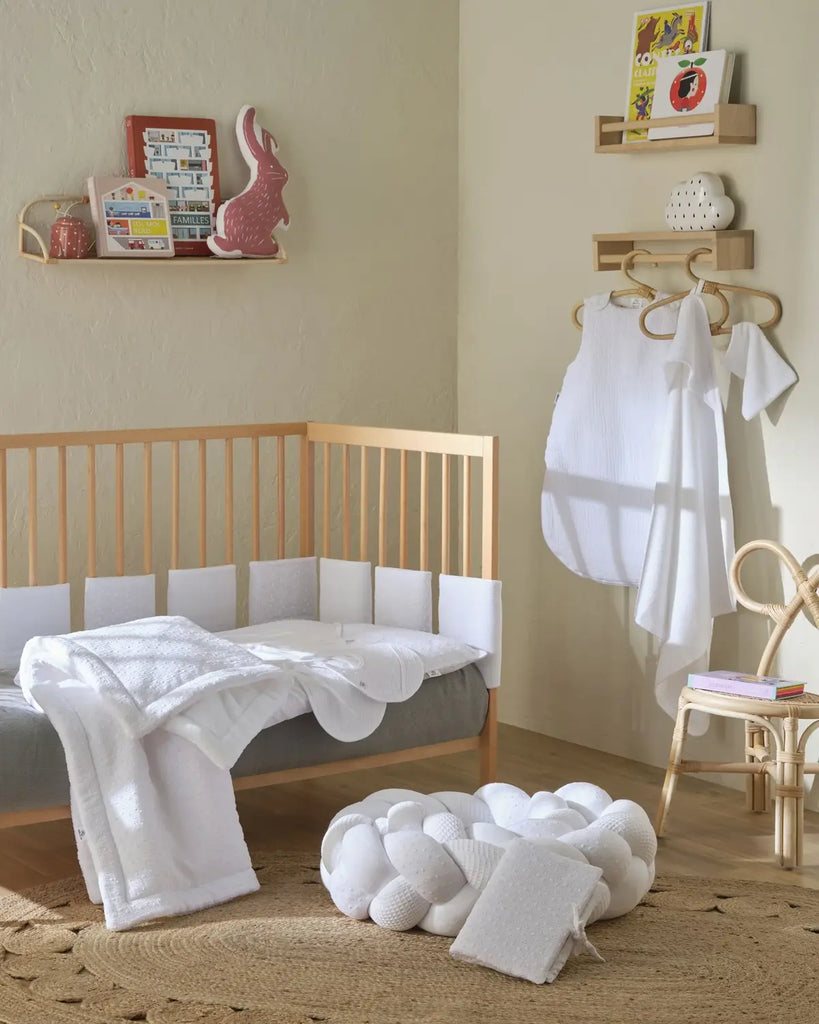 Photo d'une chambre avec des vêtements de bébé blancs