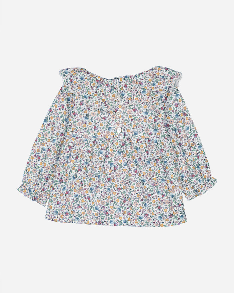 Blouse Marguerite au tissu fleurs multicolores avec des poignets volantés.