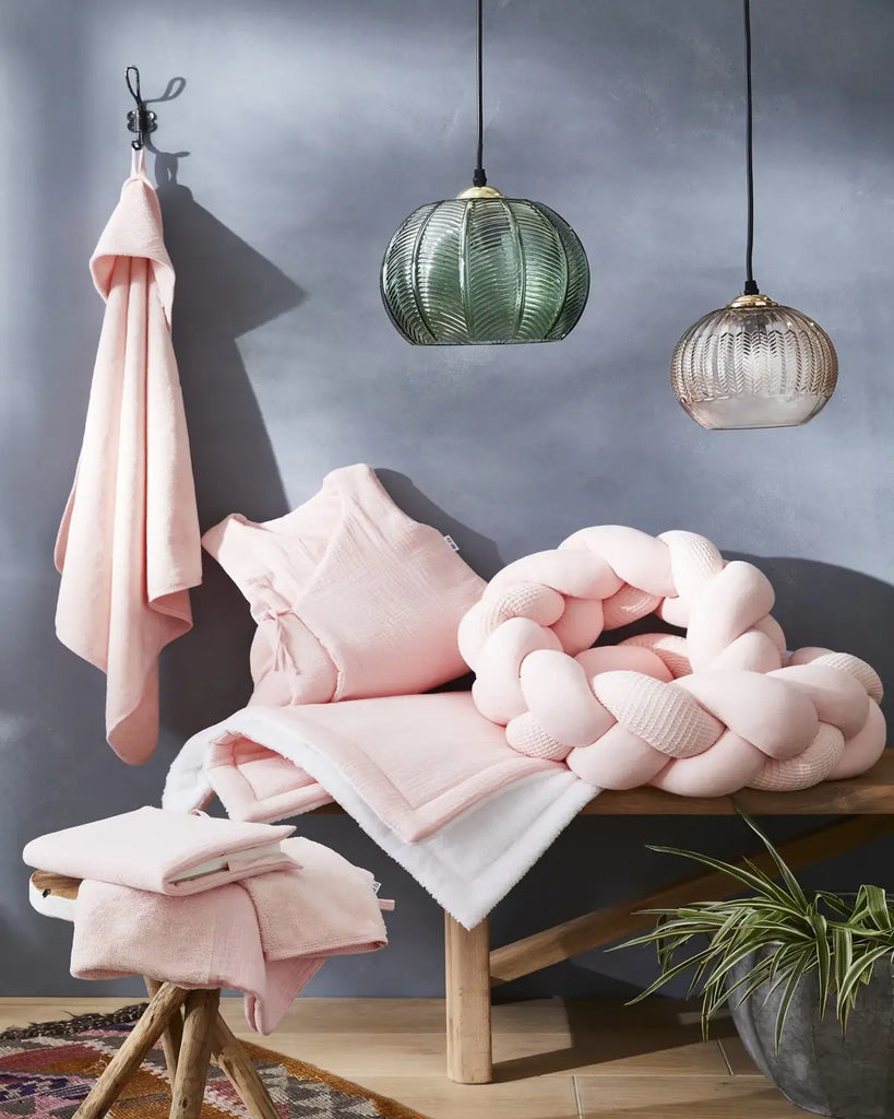 Chambre avec différents vêtements de bain de couleur rose blush pour bébé