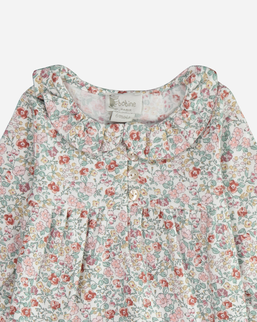 Zoom sur le col claudine de la blouse fleurie émeraude et rose .