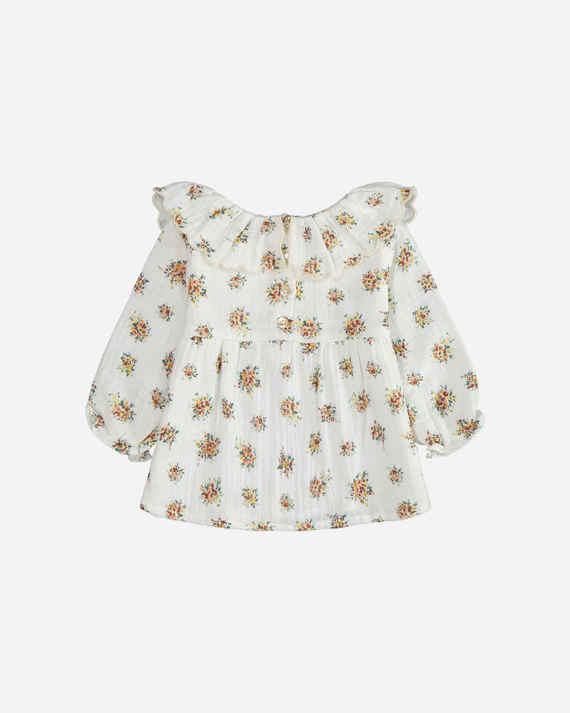 Blouse manches longues marguerite blanche fleurie jaune avec un col volanté vue de dos.