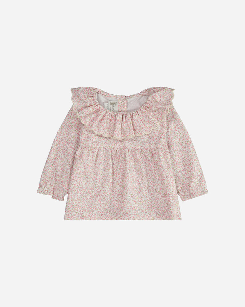 Blouse à manches longues marguerite fleurie rose avec un col volanté.