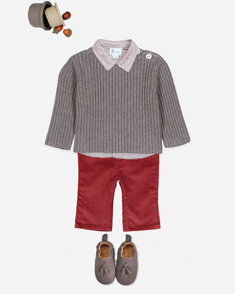 Ensemble d'un pull couleur brume taupe, une chemise à carreaux blanc et rouge, un pantalon en velours rouge et une paire de chaussures assortie au pull.